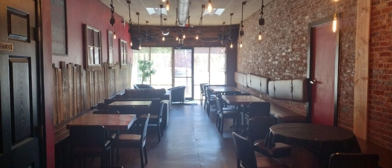 Brick Row Market dining room with brick walls and Edison bulb pendants
