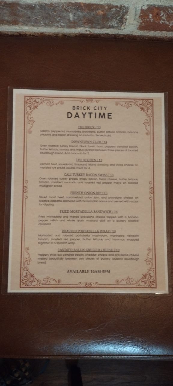 Brick City Daytime sandwich menu listing all eight signatures — The Brick, Downtown Club, The Reuben, Cali Turkey Bacon Swiss, French Onion Dip, Fried Mortadella, Roasted Portabella, Candied Bacon Grilled Cheese — available 10am-5pm