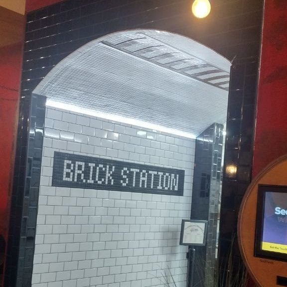The Brick Station subway-tile arch with mosaic-tile sign